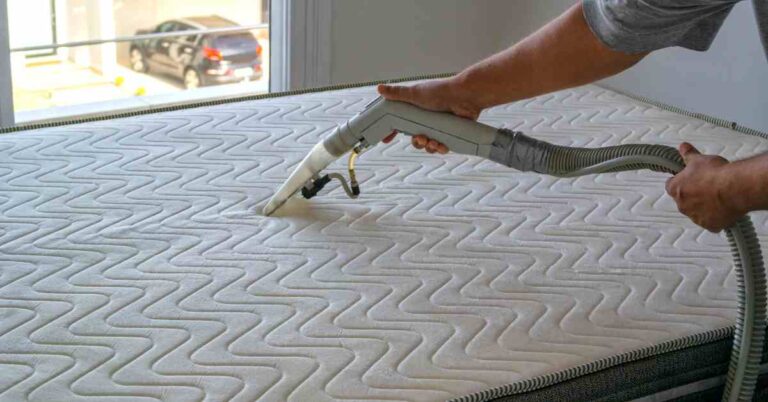 Vacuuming mattress to remove dust and debris
